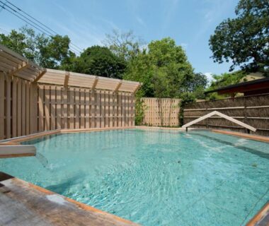 Wooden outdoor onsen bath with clear water and bamboo fence at ABBA Resorts Izu Zagyosoh in Shizuoka