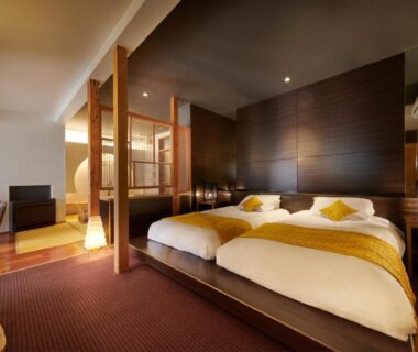Contemporary Japanese-style guest room with twin Western beds, wooden partition and seating area at AKARI et KAORI in Shizuoka
