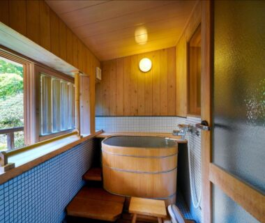 Small wooden ofuro tub with stools by large window at AKARI et KAORI in Shizuoka