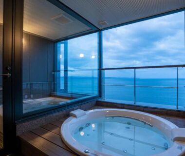 Round soaking tub on glass balcony with sea view at AMANE resort GAHAMA, Oita, Kyushu
