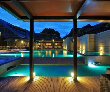 Illuminated outdoor pool with covered pavilion and wooden decking at AMANE resort GAHAMA, Ōita, Kyūshū, Japan