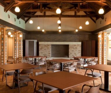 Warm timber dining area with exposed beams and pendant lights at AMANE resort GAHAMA in Ōita, Kyūshū
