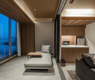 Contemporary room with daybed, sofa, kitchenette and large windows facing the sea at AMANE resort SEIKAI, Ōita