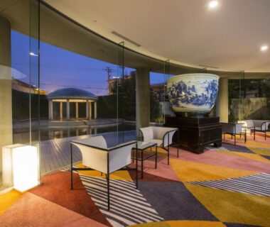 Glass-walled lounge with large decorative porcelain urn, modern chairs and patterned carpet at APA Kaga Katayamazu in Ishikawa