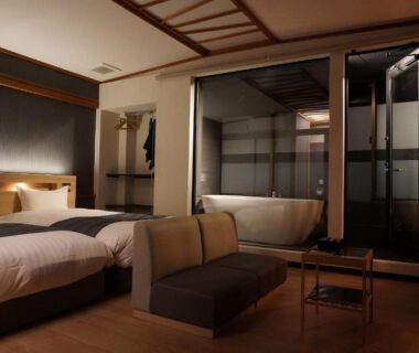 Twin beds and in-room bathtub with glass partition at AWA Nishi-Izu, Shizuoka modern ryokan interior
