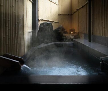 Steaming wooden indoor onsen bath with bamboo walls at AWA Nishi-Izu, Shizuoka