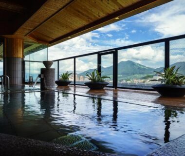 Indoor onsen bath with floor-to-ceiling windows overlooking mountains at Aburaya Tousen in Nagano, Chūbu