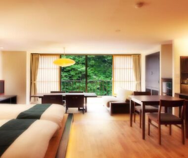 Spacious twin-bed room with low table and garden view at Shosuke no Yado Takinoyu Fukushima