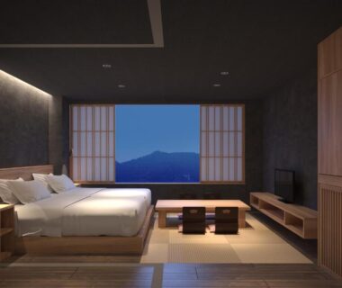 Spacious tatami bedroom with low beds, shoji screens and framed mountain view at Aizu Higashiyama Onsen Tsuki no Akari Fukushima