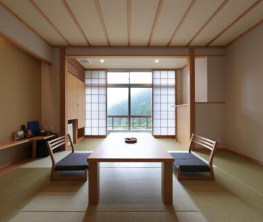 Traditional tatami room with low table, shoji screens and balcony window at Akagi Onsen Hotel Gunma