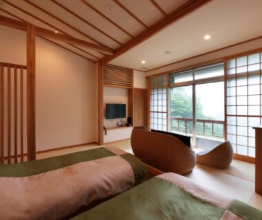 Tatami flooring, futon beds, shoji screens and balcony overlooking greenery at Akagi Onsen Hotel, Gunma