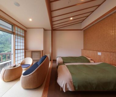Twin beds on tatami with shoji and balcony overlooking greenery at Akagi Onsen Hotel, Gunma, Kantō