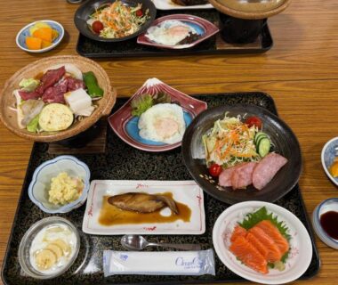 Assorted Japanese dishes including sashimi and grilled fish on lacquer trays at Akaishi Ryokan Yamanashi