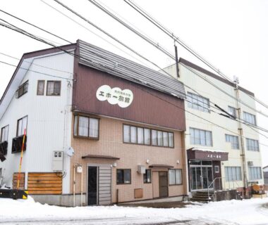 Three-story exterior of Akakura onsen eho ryokan on a snowy street in Niigata