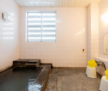 Tiled communal onsen bath with washing stools and buckets at Akakura onsen eho ryokan Niigata