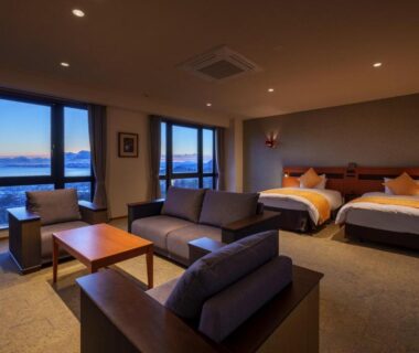 Twin beds and lounge area at Akarinoyado Togetsu with large windows in Oita