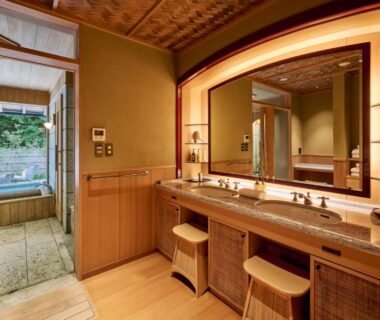Double wooden vanity with stools leading to stone onsen bath at Akazawa Geihinkan in Shizuoka
