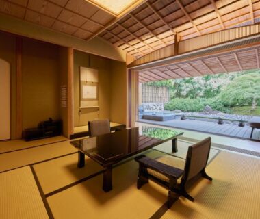 Traditional tatami room with low table and sliding doors opening to a landscaped garden at Akazawa Geihinkan, Shizuoka