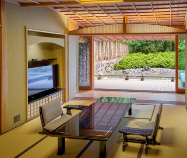 Tatami room with low table, zaisu chairs and garden veranda at Akazawa Geihinkan, Shizuoka