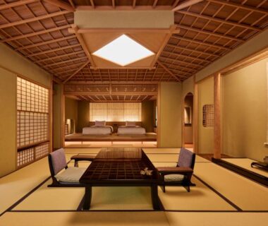 Traditional tatami room with low table, floor chairs and futon sleeping area at Akazawa Geihinkan Shizuoka