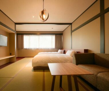 Tatami room with twin beds, low table, sofa and wall-mounted TV at Akiu Fuga, Miyagi, Tōhoku Japan