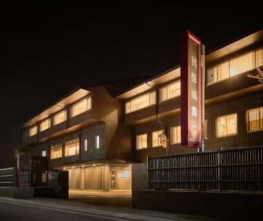 Illuminated ryokan exterior at night with wooden façade and lit windows, Akiu Fuga in Miyagi, Tōhoku