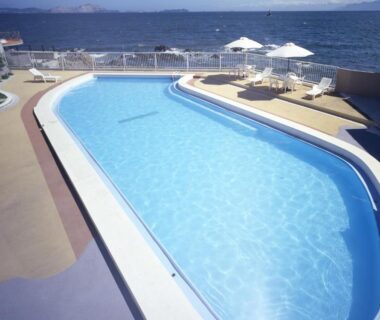Outdoor pool with loungers and umbrellas overlooking the sea at Ako Onsen Shiosaikirara Shokichi, Hyōgo