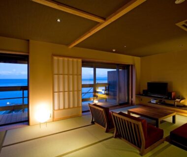 Tatami room with low table, shoji screens and balcony overlooking the sea at Amahara Hyōgo Kansai