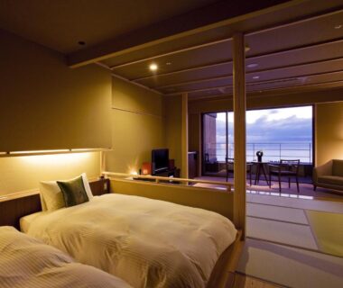 Tatami room with twin beds, shoji screens and balcony overlooking water at Amahara in Hyōgo, Kansai