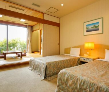 Twin beds with tatami seating area and garden view at Amanohashidateso in Kyoto