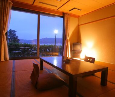 Tatami room with low table and sliding doors opening to a landscape view at Amanohashidateso, Kyoto