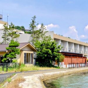 Waterfront building with seawall and trees at Amanohashidateso in Kyoto, Kansai