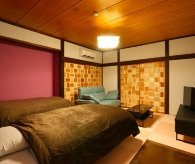 Tatami floor room with twin beds, sofa and shoji screens at Amis Droles Shizuoka
