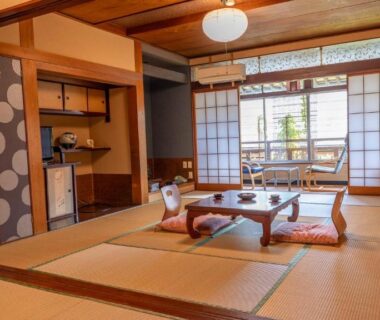 Traditional tatami room with low table, floor cushions, shoji screens and garden view balcony at Andaikan Nagano