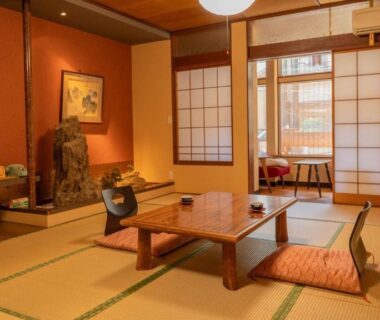 Traditional tatami room with low wooden table, zabuton cushions, shoji screens and tokonoma at Andaikan Nagano