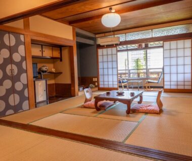Tatami room with low table, floor cushions and shoji screens overlooking a garden at Andaikan in Nagano
