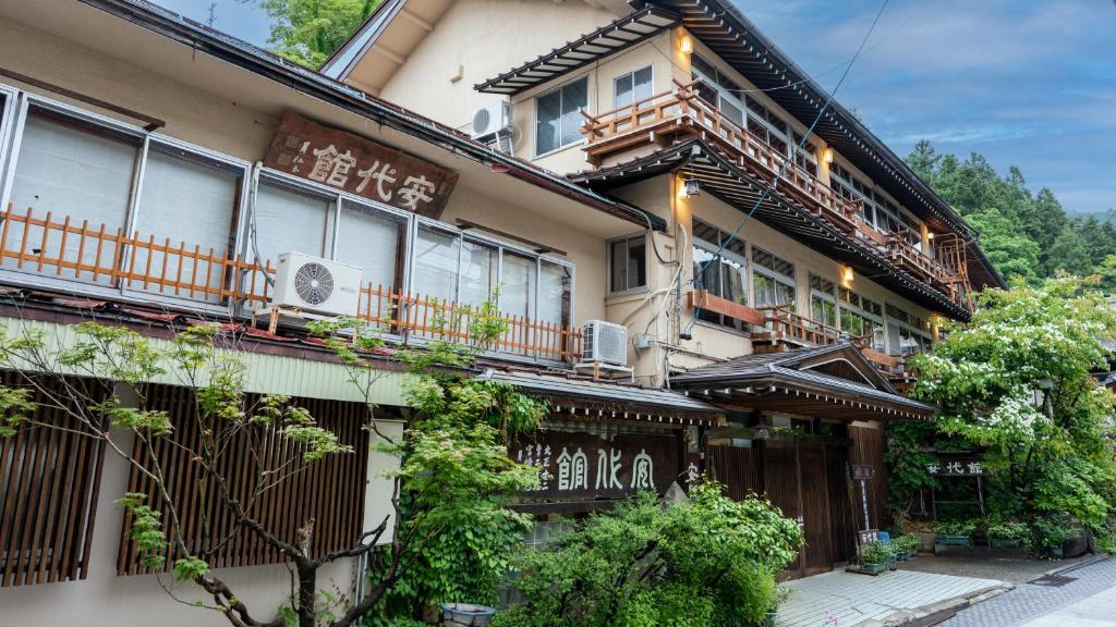 Wooden ryokan exterior at Andaikan Nagano Multi-story traditional ryokan facade with wooden balconies and greenery in Nagano's Chūbu region