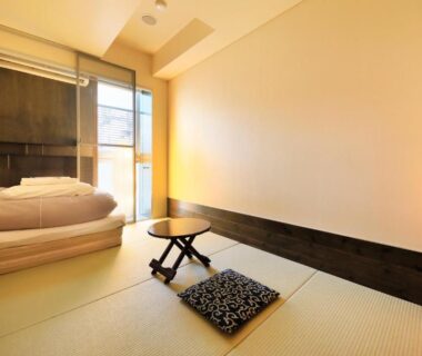 Tatami room with folded futon and low table at Andon Ryokan in Tokyo