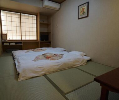 Compact tatami room with futon bedding, shoji screen window, low table and minimalist decor at Annex Katsutaro Tokyo