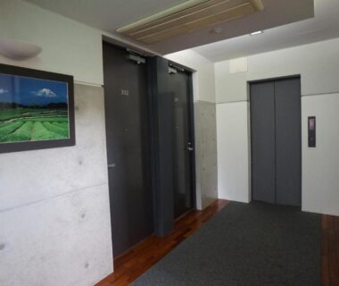 Hallway with elevators and framed landscape at Annex Katsutaro Ryokan in Tokyo