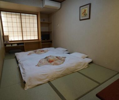 Japanese tatami room with two futons, shoji window and low desk at Annex Katsutaro Ryokan in Tokyo
