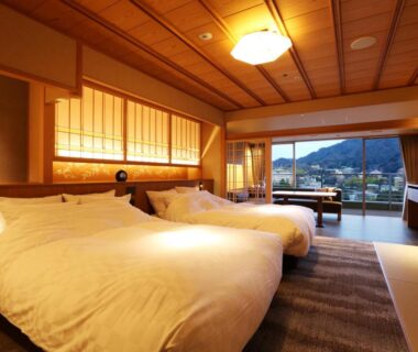 Spacious twin room with tatami area, shoji screens and balcony view of nearby hills at Arima Grand Hotel Hyōgo