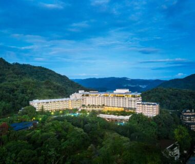 Illuminated Arima Grand Hotel complex nestled in forested hills and distant mountains in Hyōgo, Kansai