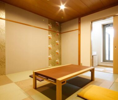 Tatami room with low wooden table, zabuton cushions and shoji door at Arima Hot Spring Ryokan Kotori in Hyōgo