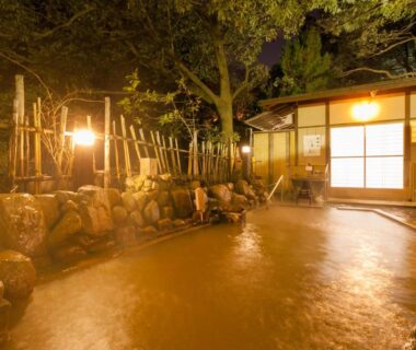 Outdoor stone onsen bath at Arima Onsen Gekkoen Yugetsusanso in Hyōgo with evening lantern lighting