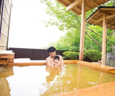 Parent and child in wooden outdoor onsen at Arima Onsen Motoyu Ryuusenkaku Hyōgo