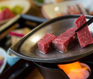 Beef cubes cooking on a small tabletop grill with side dishes at Arima Onsen Motoyu Ryuusenkaku Hyōgo