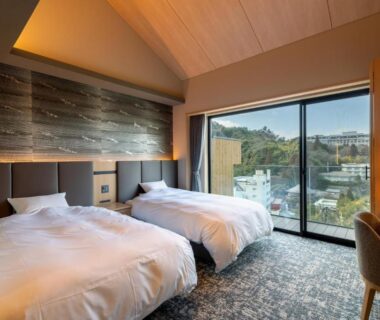 Twin beds in contemporary room with large window at Arima Onsen ShikinoIrodori Hatago, Hyōgo, Japan