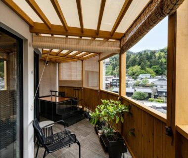Wooden balcony with chairs overlooking town and green hills at Arima Onsen ShikinoIrodori Hatago Hyōgo