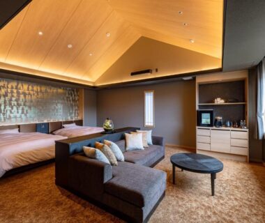 Spacious room with twin beds, sofa and wooden vaulted ceiling at Arima Onsen ShikinoIrodori Hatago, Hyōgo Japan